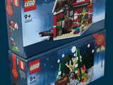 two boxes of legos with a christmas scene on them on a blue background