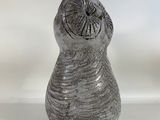 a gray vase that is sitting on a white surface
