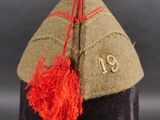 an image of a military hat with a red tassel on it