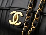 a close up of a chanel bag with a chain around it