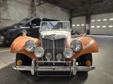 une voiture orange et blanche garée dans un garage