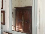 un miroir accroché au mur au-dessus d'une commode dans une pièce