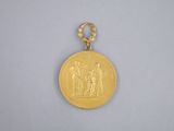 a close up of a gold medal on a white surface
