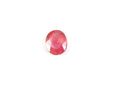 a close up of a red ruby stone on a white surface