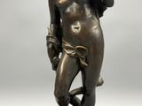 bronze statue of a woman holding a flower in her right hand