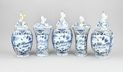 six vases bleus et blancs sont alignés sur un fond gris