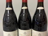 trois bouteilles de vin rouge sont alignées sur une table