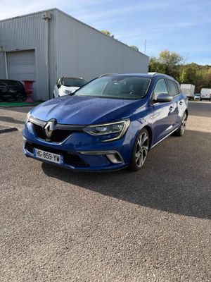 une voiture bleue garée dans un parking à côté d'un bâtiment