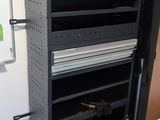 a black and red shelf in the corner of a room