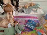 a woman that is holding a stuffed animal next to a pile of toys