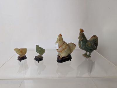 cinq figurines d'oiseaux posées sur une étagère transparente