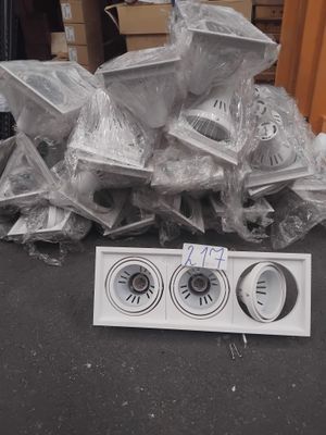 un tas d'appareils électroniques posé par terre à côté d'une pile de cartons