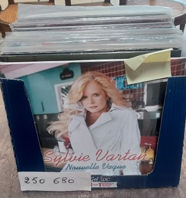 une boîte de CD posée par terre à côté d'une chaise