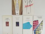 four books on a white wall with a tie, shirt, tie, and other items