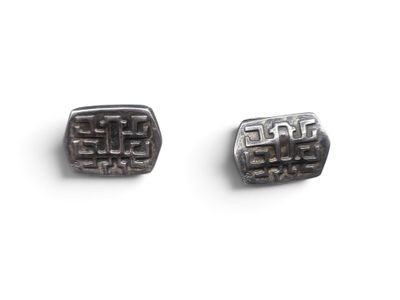 pair of black and silver cufflinks on a white surface