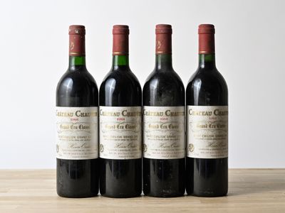 three bottles of wine are lined up on a wooden table