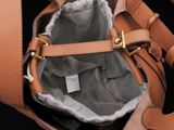 a brown bag with a handle on a black background