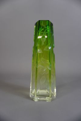 un vase en verre vert posé sur une surface blanche