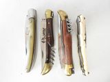 four different types of knives are lined up on a white surface