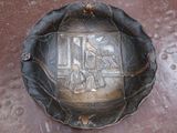une plaque métallique sur laquelle figure l'image d'un homme et d'un chien