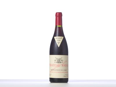 a bottle of red wine sitting on top of a white table