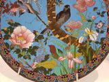 a decorative plate with birds and flowers on it