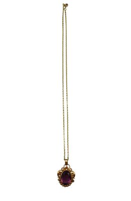 a gold necklace with a purple stone on a chain