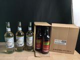Plusieurs bouteilles d'alcool sont posées dans une boîte en carton sur une table