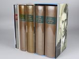 three books are stacked on top of each other on a table