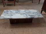 une table basse avec un plateau en marbre et un piètement en bois