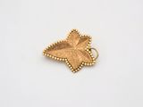 un pendentif en feuille d'or aux bords ornés de perles, sur fond blanc