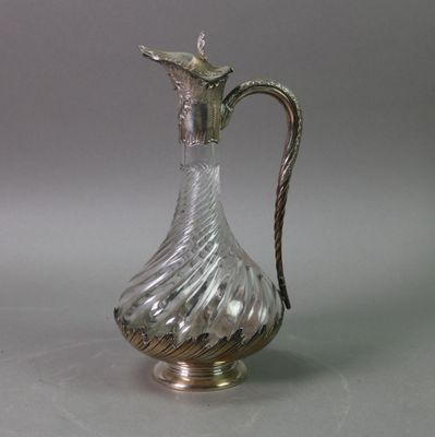 a silver and glass pitcher sitting on a table