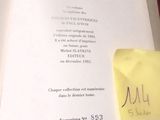 un livre ouvert sur lequel se trouve une feuille de papier