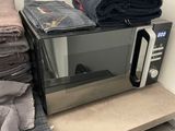 a microwave that is sitting on a shelf in a bathroom