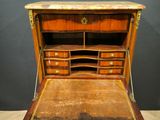 an antique writing desk with drawers and a marble top