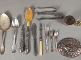 de nombreux types d’argenterie et de cuillères disposés sur une table