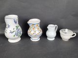 four different types of vases and bowls are lined up on a black surface