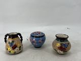 three small vases sitting on top of a table next to each other