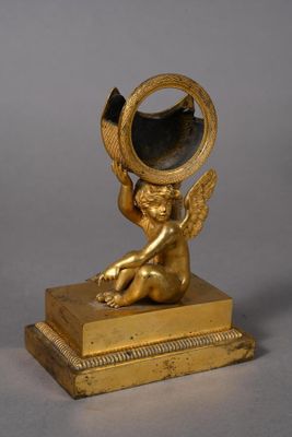 gold plated figurine of a cupid holding a mirror