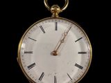 une montre de poche en or avec des chiffres romains sur le cadran