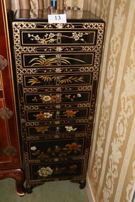 une commode noire et dorée dans un coin de la pièce