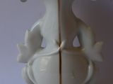 a white vase with a gold trim and a bird on it