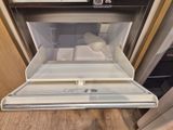 un micro-ondes posé à même le sol dans la cuisine