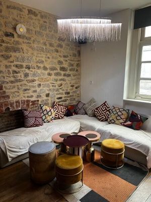 un salon avec un mur en pierre et un grand canapé