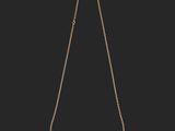 a gold necklace with a chain that has been cut in half and has been placed on a black background