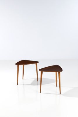 a pair of side tables in the style of person