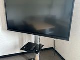 un téléviseur à écran plat sur un support dans le coin d'une pièce