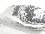 a piece of silver foil on a white surface