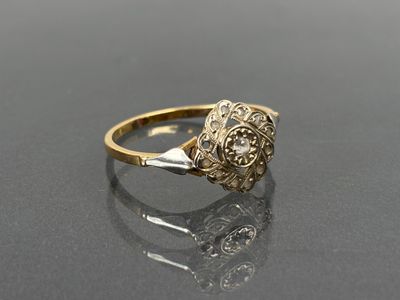gros plan d'une bague en or et diamants sur une surface noire