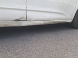 a white car that is parked on the side of the road